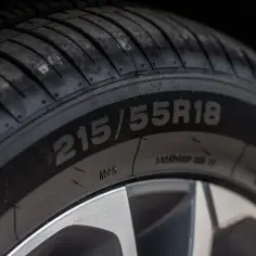 Zbliżenie na oponę z widocznym rozmiarem 215/55R18. Ten rozmiar opony zapewnia optymalną przyczepność.