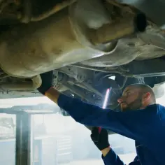Mechanik bada podwozie Opla, szukając przyczyny błędu DTC P0420.