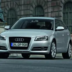 Srebrne Audi A3 2004 na tle zabytkowej kamienicy. Eleganckie auto z charakterystycznym grillem i reflektorami.