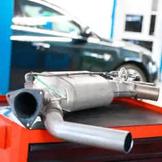 Filtr DPF do Forda, być może z powodu błędu DTC P2002, leży na wózku warsztatowym.
