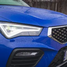Błękitny Seat Ateca FR z kroplami deszczu na masce i reflektorami LED.