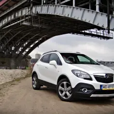 Biały Opel Mokka 1.4 Turbo pod mostem. Czy są jakieś wady tego modelu?
