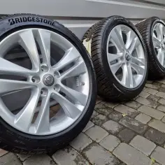 Felgi aluminiowe do Astry J, z oponami Bridgestone. Rozstaw śrub 5x115.