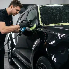 Profesjonalista aplikuje powłokę ceramiczną na auto, nadając mu lustrzany połysk i ochronę.