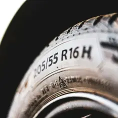 Zbliżenie na oponę z widocznym oznaczeniem 205/55 R16 H. To ważne oznaczenie opon informuje o ich rozmiarze i indeksie prędkości.
