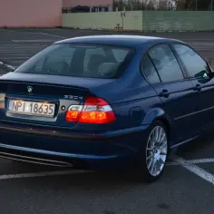 Granatowe BMW E46 330d na parkingu. Wiele osób szuka opinii o tym modelu, a ten egzemplarz wygląda świetnie.