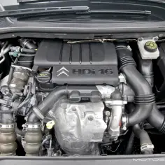 Silnik 1.6 HDI w samochodzie Citroen. Widoczne elementy układu dolotowego, turbosprężarki i osłony silnika.