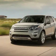 Szary Land Rover Discovery Sport w ruchu. Wiele osób szuka **land rover discovery sport opinie** przed zakupem.