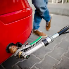 Tankowanie gazu do czerwonego samochodu. Zastanawiasz się, ile kosztuje przegląd z gazem?