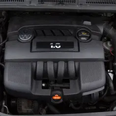 Silnik Volkswagena z oznaczeniem 1.6 MPI. Widoczny zbiornik płynu chłodniczego i inne elementy komory silnika.