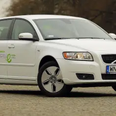 Białe Volvo V50 z zielonym napisem "ECONOMIZNY DRIVE" i informacją o niskim spalaniu. Wiele osób szuka takich aut, czytając volvo v50 opinie.