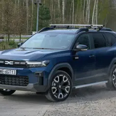 Dacia Bigster LPG na drodze leśnej, z bagażnikiem dachowym.
