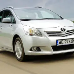Srebrna Toyota Verso 1.8 benzyna w ruchu, z zielonym polem w tle.