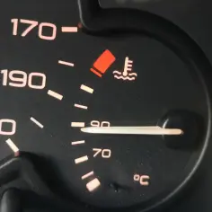 Wskaźnik pokazuje, że temperatura płynu chłodniczego jest w normie, blisko 90°C. Czerwona kontrolka ostrzega przed przegrzaniem.