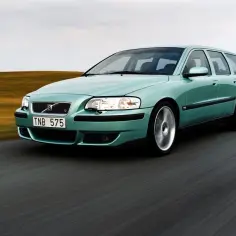 Zielony Volvo V70 II pędzi po drodze, krajobraz za nim rozmazany.