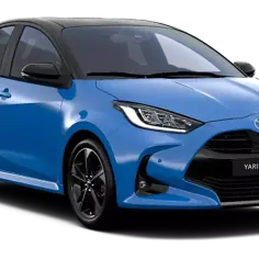 Niebieski Yaris Hybrid z czarnym dachem i przyciemnianymi szybami, prezentujący nowoczesny design i ekologiczne rozwiązanie napędowe.