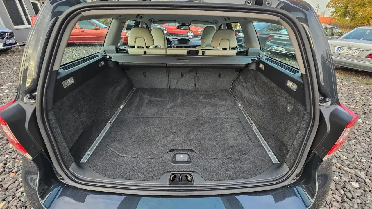 Pusta przestrzeń bagażowa Volvo V70 II, gotowa na podróż. Wnętrze czyste, wyłożone wykładziną.