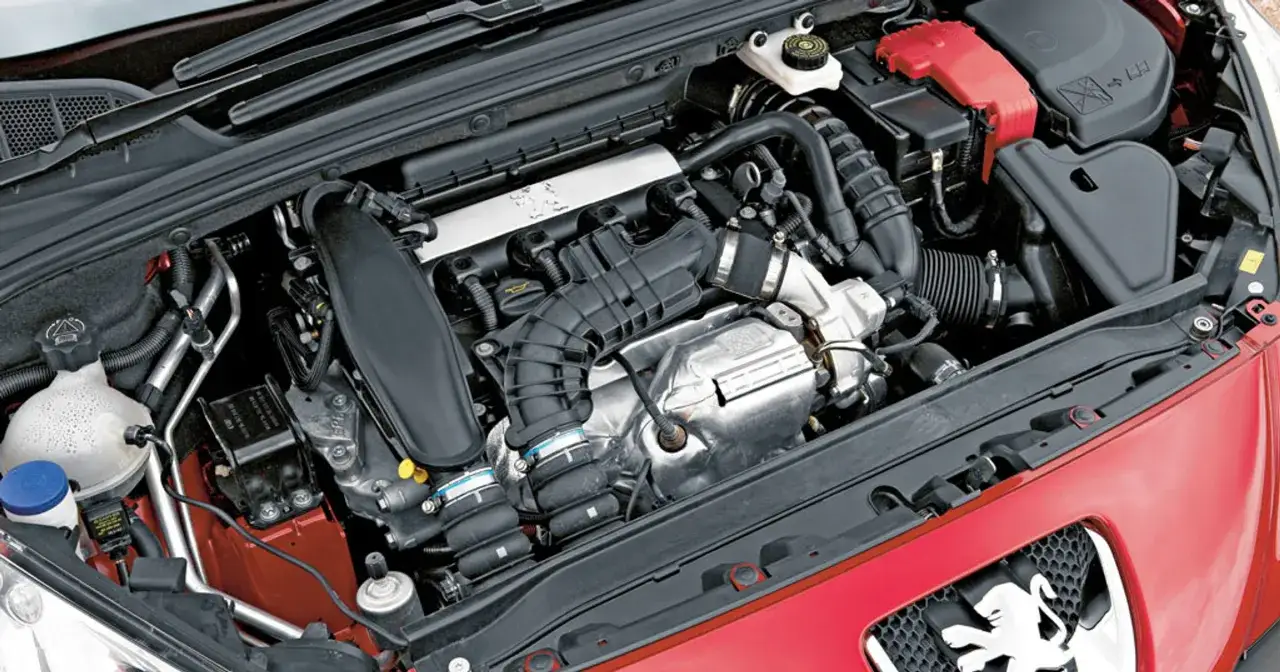 Silnik 1.6 PureTech w samochodzie Peugeot. Widoczne elementy układu dolotowego, chłodzenia i akumulator.