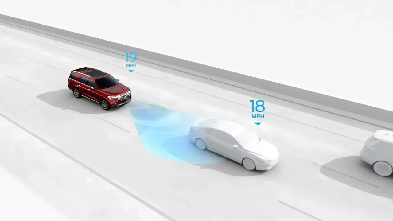 Czerwony SUV z włączonym tempomatem adaptacyjnym zwalnia, by utrzymać bezpieczną odległość od białego sedana jadącego przed nim.