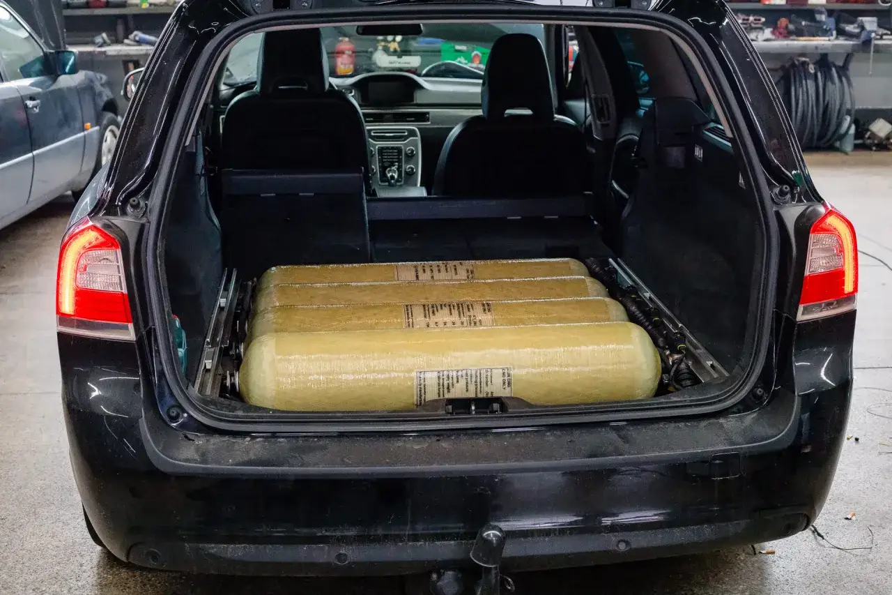 Bagażnik czarnego kombi wypełniony czterema butlami CNG/LPG.