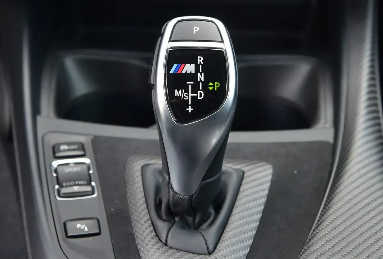 Dźwignia automatycznej skrzyni biegów BMW M z podświetlanymi trybami jazdy: P, R, N, D, M/S.