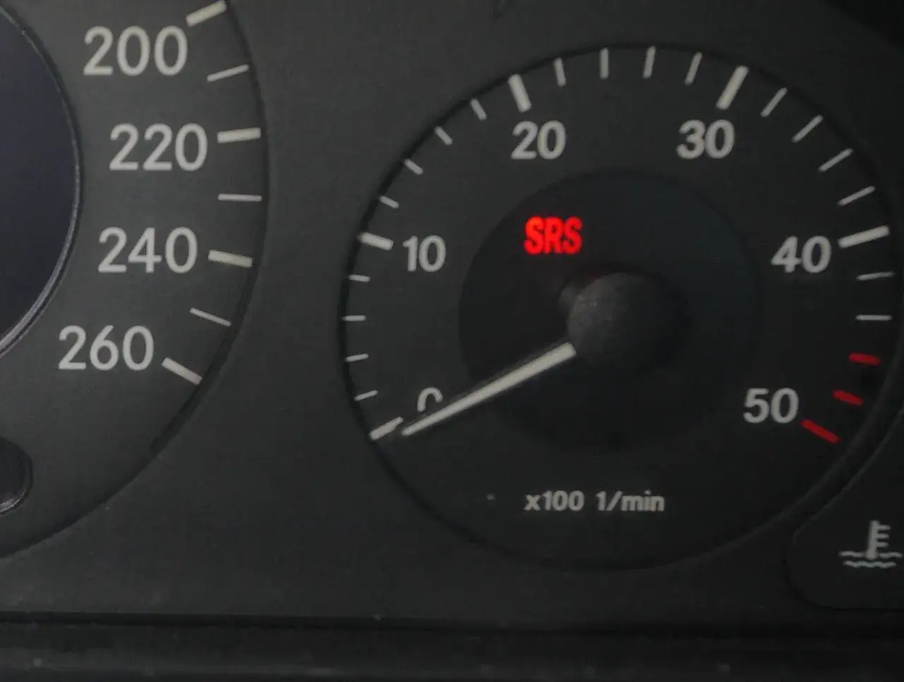 Czerwona kontrolka SRS świeci na desce rozdzielczej Mercedesa, sygnalizując problem z systemem poduszek powietrznych.