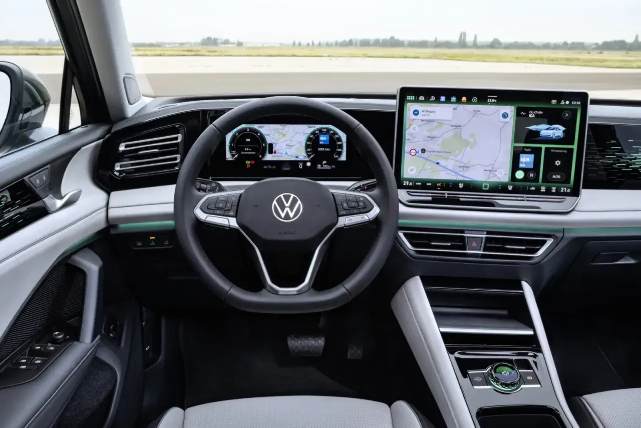 Wnętrze Volkswagena Tiguana z nowoczesnym ekranem nawigacji i cyfrowymi zegarami. Wiele osób szuka takich volkswagen tiguan opinie przed zakupem.